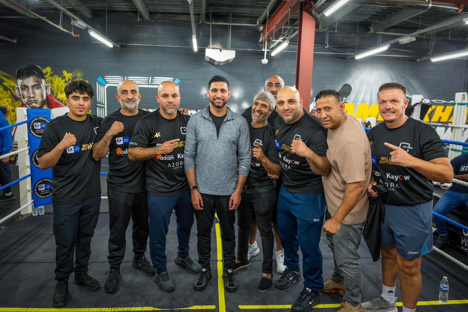 Amir Khan standing with Top Yard boxers and coaches inside the Queensgate gym