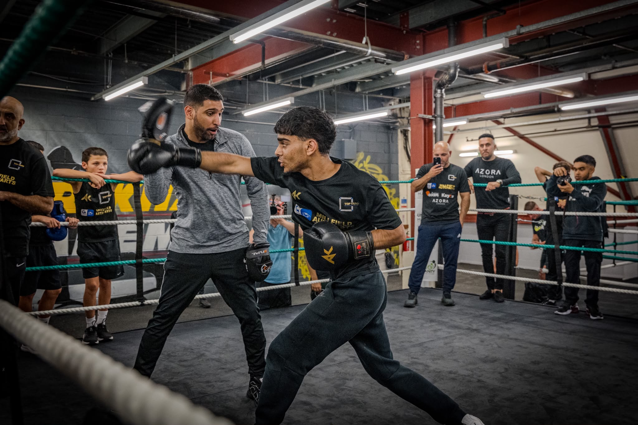 Amir Khan coaching a young boxer inside the Top Yard ring